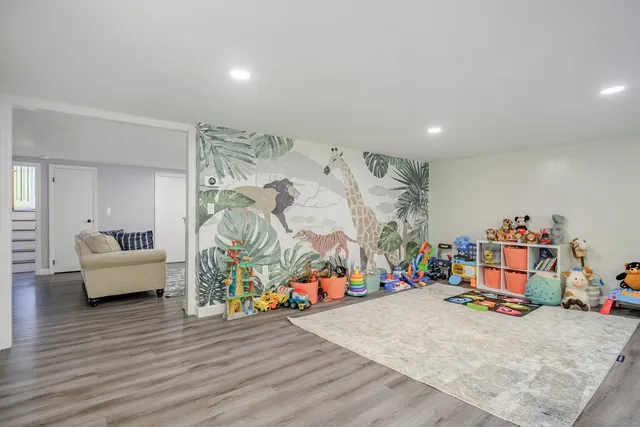 a view of a room with wooden floor and furniture