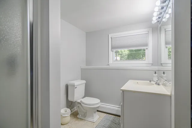 a bathroom with a toilet sink and mirror