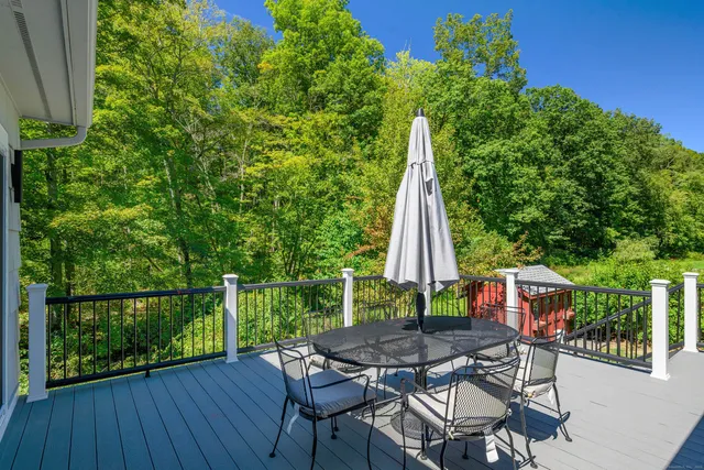 a view of a patio with table and chairs with wooden floor and fence
