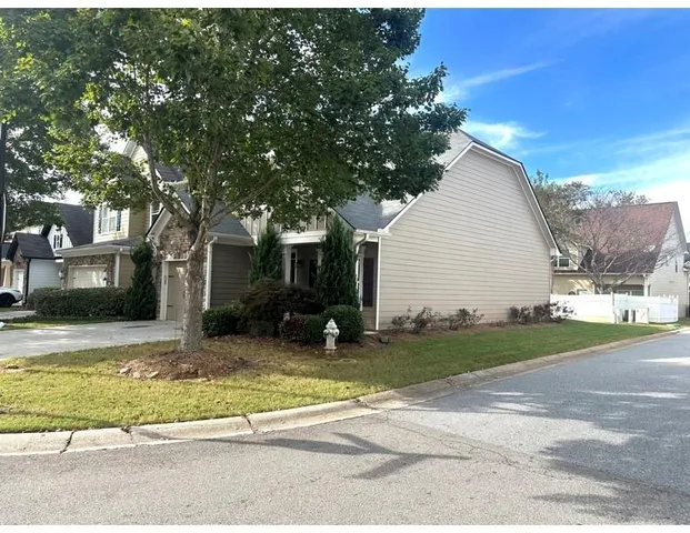 a view of a house with a patio and a yard