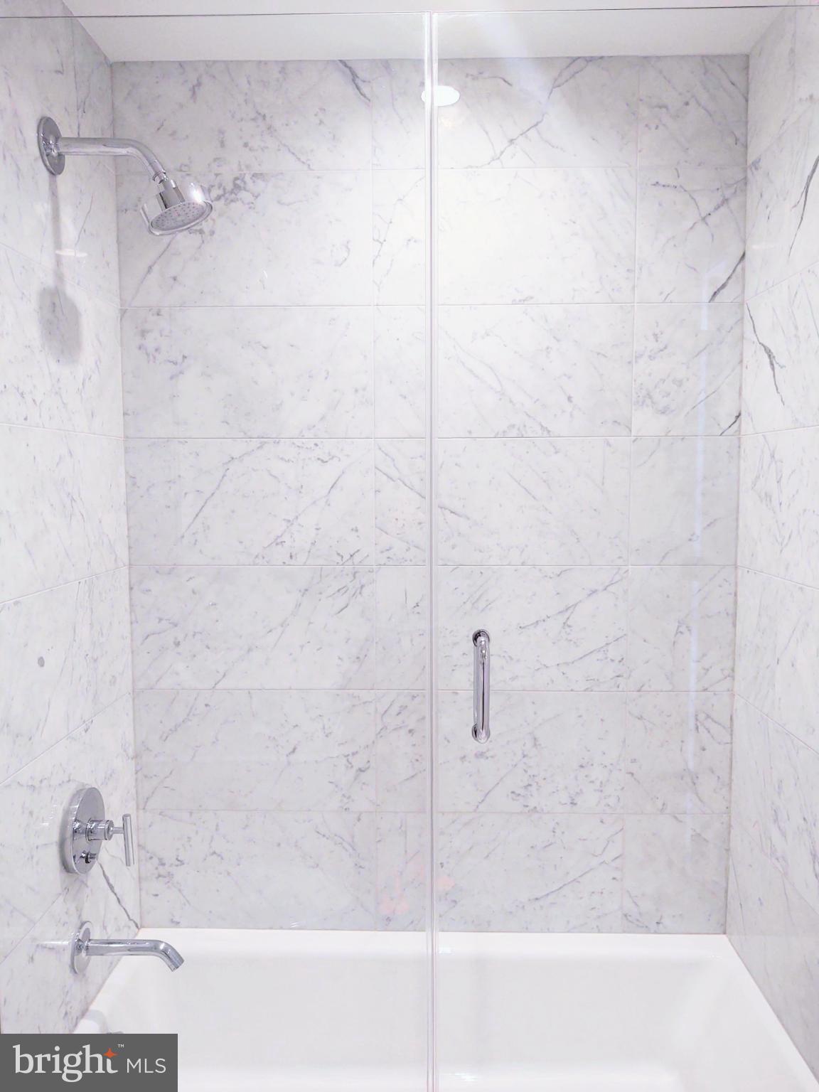 45 Sutton Square Southwest, Unit 1112 Washington, DC 20024 - Photo 19 of 46 Sleek marble shower with modern fixtures.