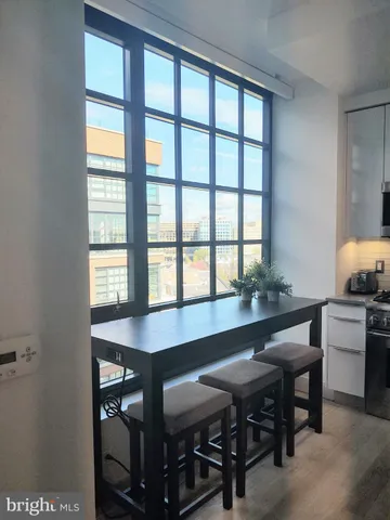 a bedroom with a bed and dresser with wooden floor