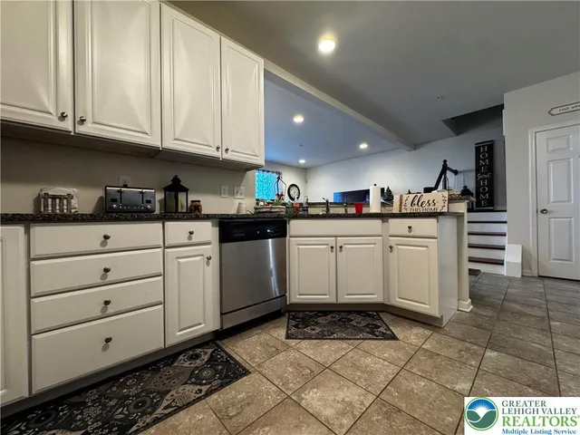 a kitchen with granite countertop a sink cabinets and stainless steel appliances