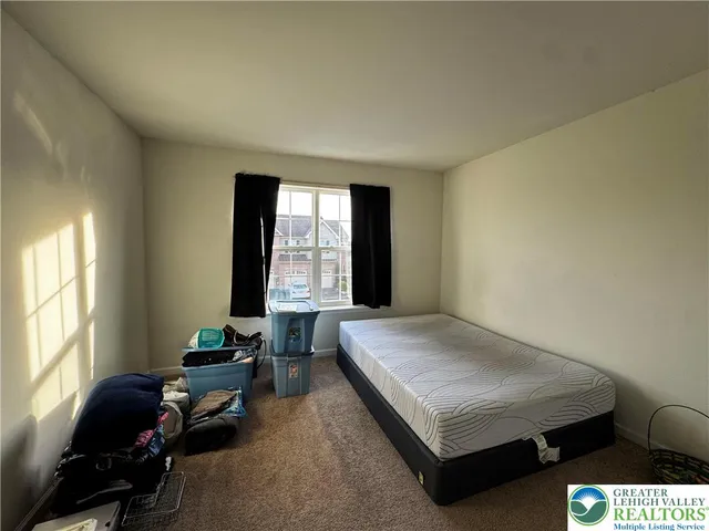 a bedroom with a bed and windows