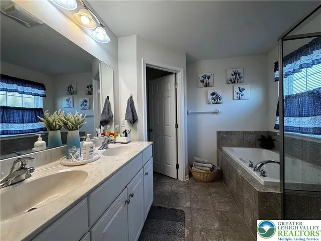 a bathroom with a tub sink and mirror