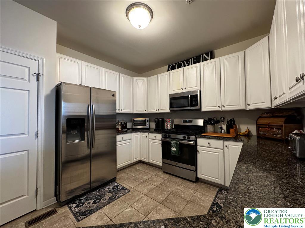 4466 Cottonwood Drive Nazareth, PA 18064 - Photo 9 of 22 a kitchen with granite countertop a refrigerator and a stove top oven
