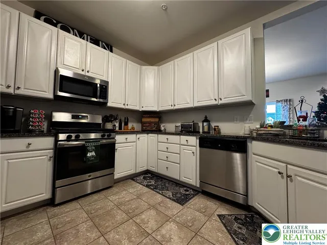 a kitchen with granite countertop a stove top oven microwave and cabinets