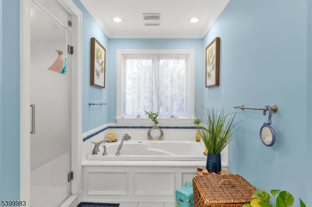 a bathroom with a tub sink and mirror