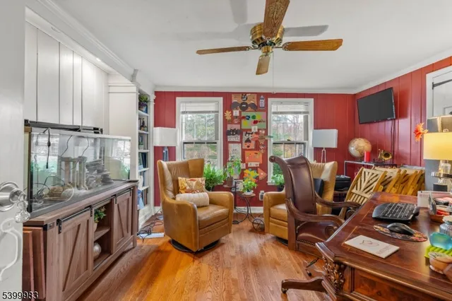 a living room with furniture a flat screen tv and a floor to ceiling window