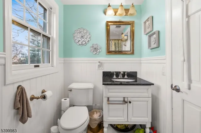 a bathroom with a granite countertop toilet sink and mirror