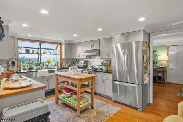 a kitchen with stainless steel appliances granite countertop a refrigerator and a stove top oven