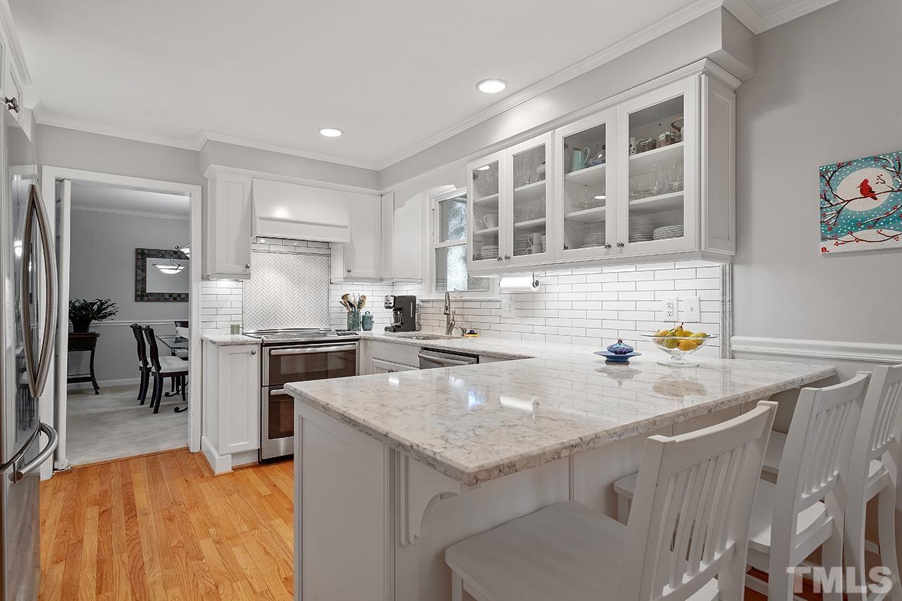 2408 Wentworth Street Raleigh, NC 27612 - Photo 18 of 33 a kitchen with a sink a stove and chairs