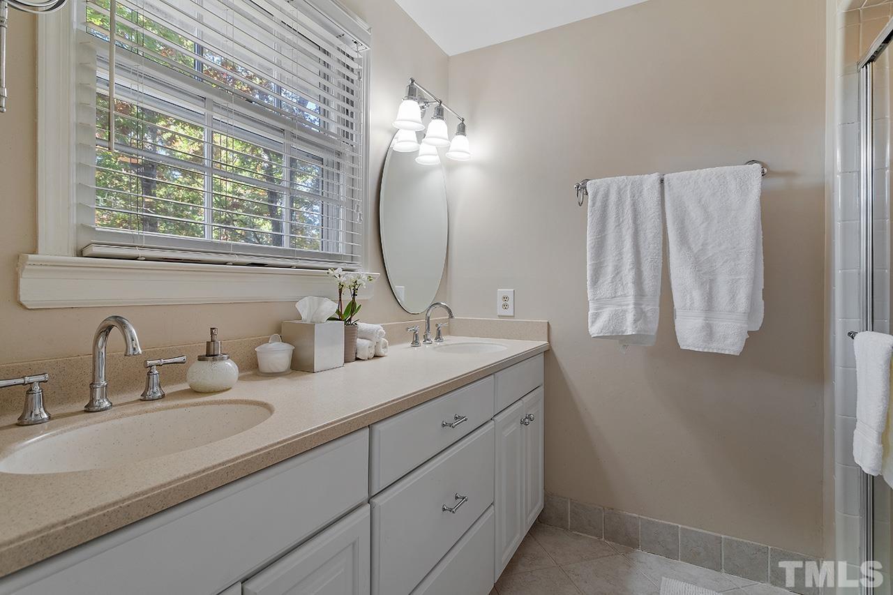 2408 Wentworth Street Raleigh, NC 27612 - Photo 25 of 33 a bathroom with a double vanity sink and mirror