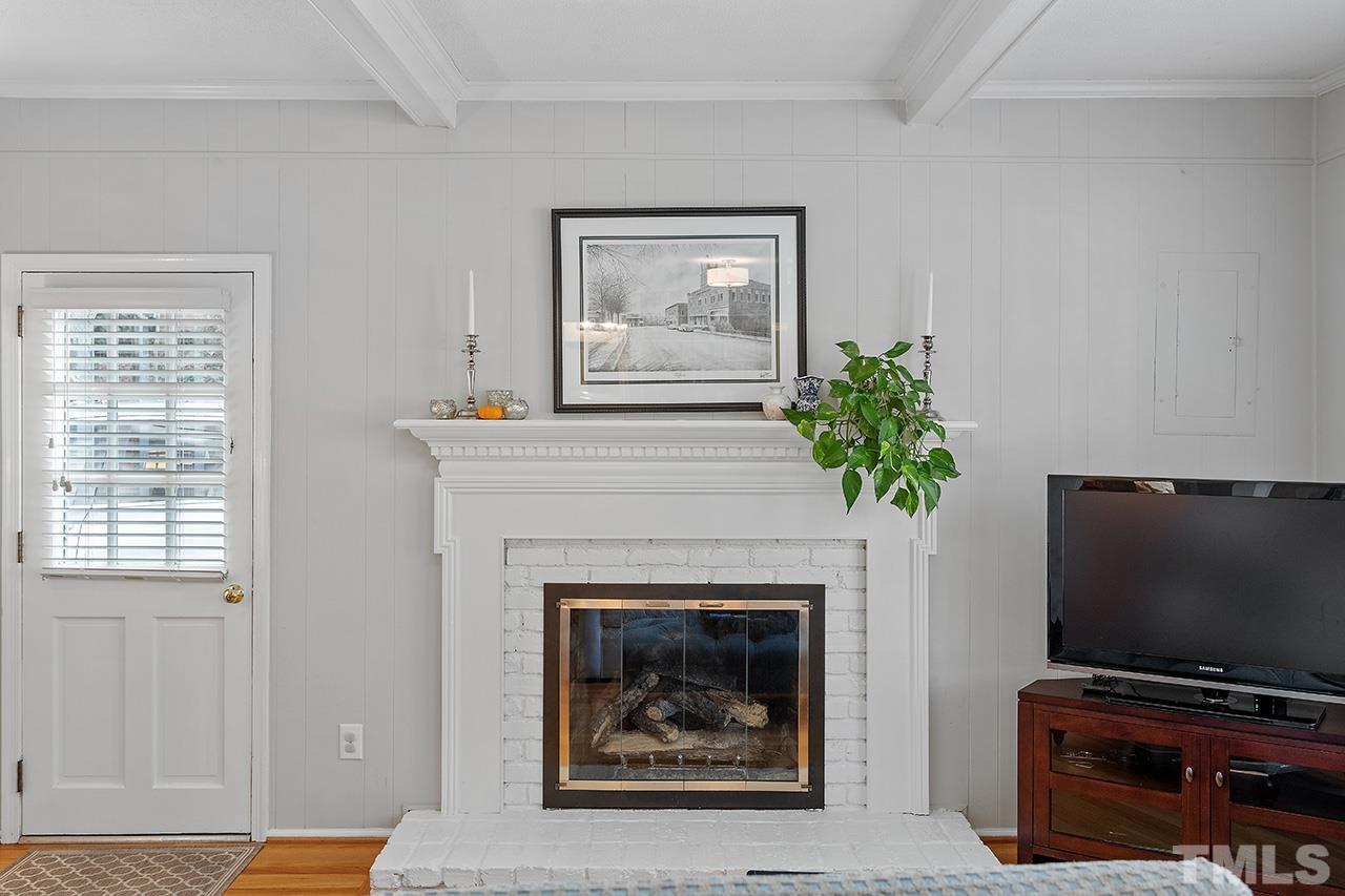2408 Wentworth Street Raleigh, NC 27612 - Photo 5 of 33 a living room with a fireplace and a flat screen tv