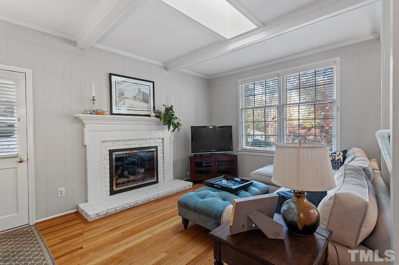 2408 Wentworth Street Raleigh, NC 27612 - Photo 7 of 33 a living room with furniture a flat screen tv and a fireplace