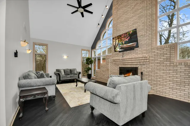 a dining room with wooden floor a chandelier a wooden table and chairs