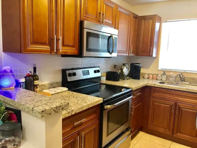 a kitchen with stainless steel appliances granite countertop a sink stove and microwave