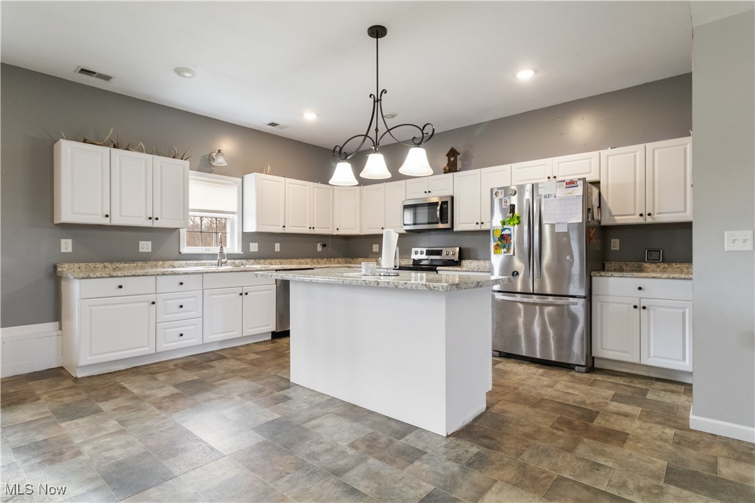 57459 Shry Road Barnesville, OH 43713 - Photo 6 of 44 Kitchen featuring appliances with stainless steel finishes, white cabinetry, decorative light fixtures, light stone counters, and recessed lighting