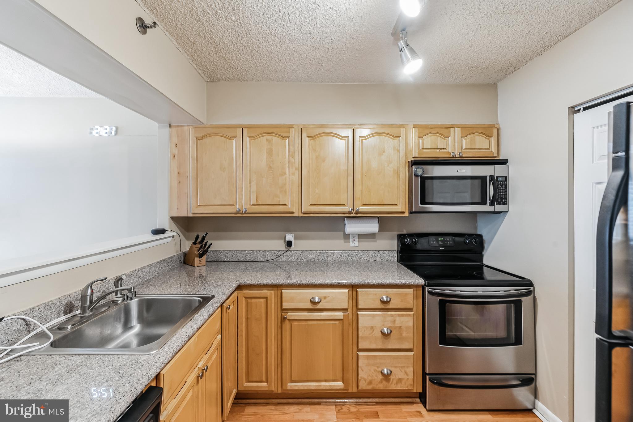 2201 Cherry Street, Unit 603 Philadelphia, PA 19103 - Photo 18 of 32 a kitchen with granite countertop a sink a stove and cabinets