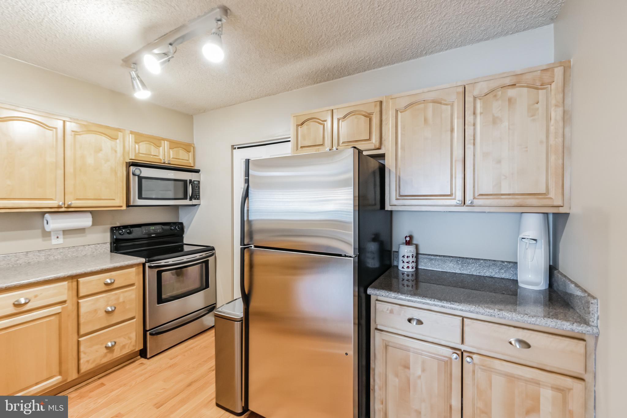 2201 Cherry Street, Unit 603 Philadelphia, PA 19103 - Photo 20 of 32 a kitchen with granite countertop a refrigerator stove and sink