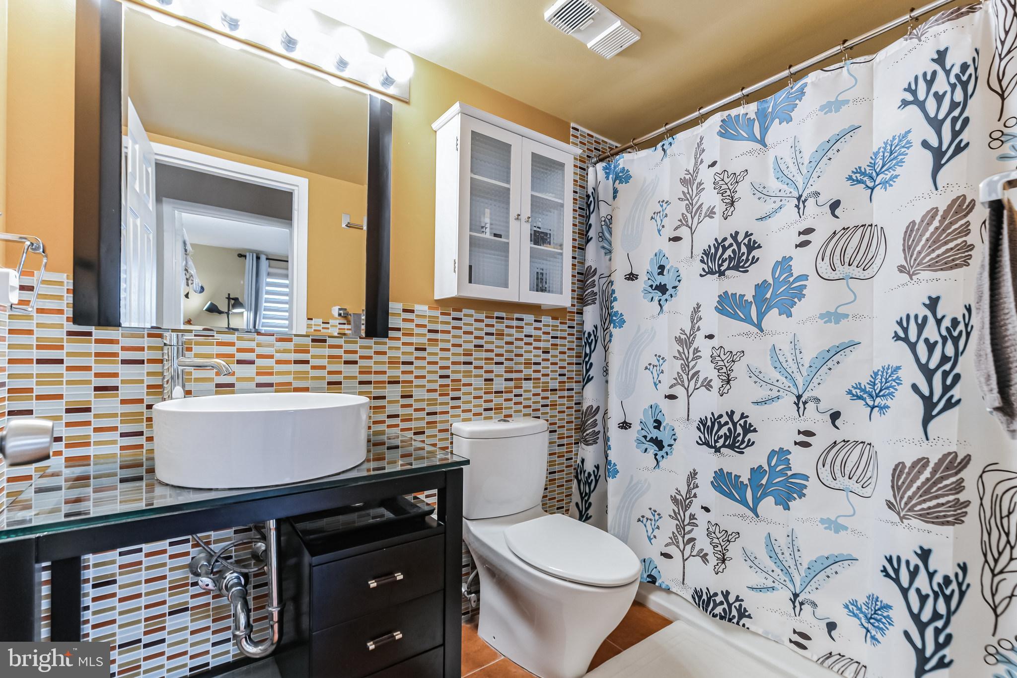 2201 Cherry Street, Unit 603 Philadelphia, PA 19103 - Photo 26 of 32 a bathroom with a granite countertop toilet sink and mirror