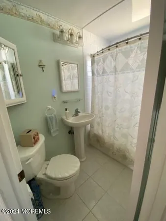 a bathroom with a toilet a sink and shower
