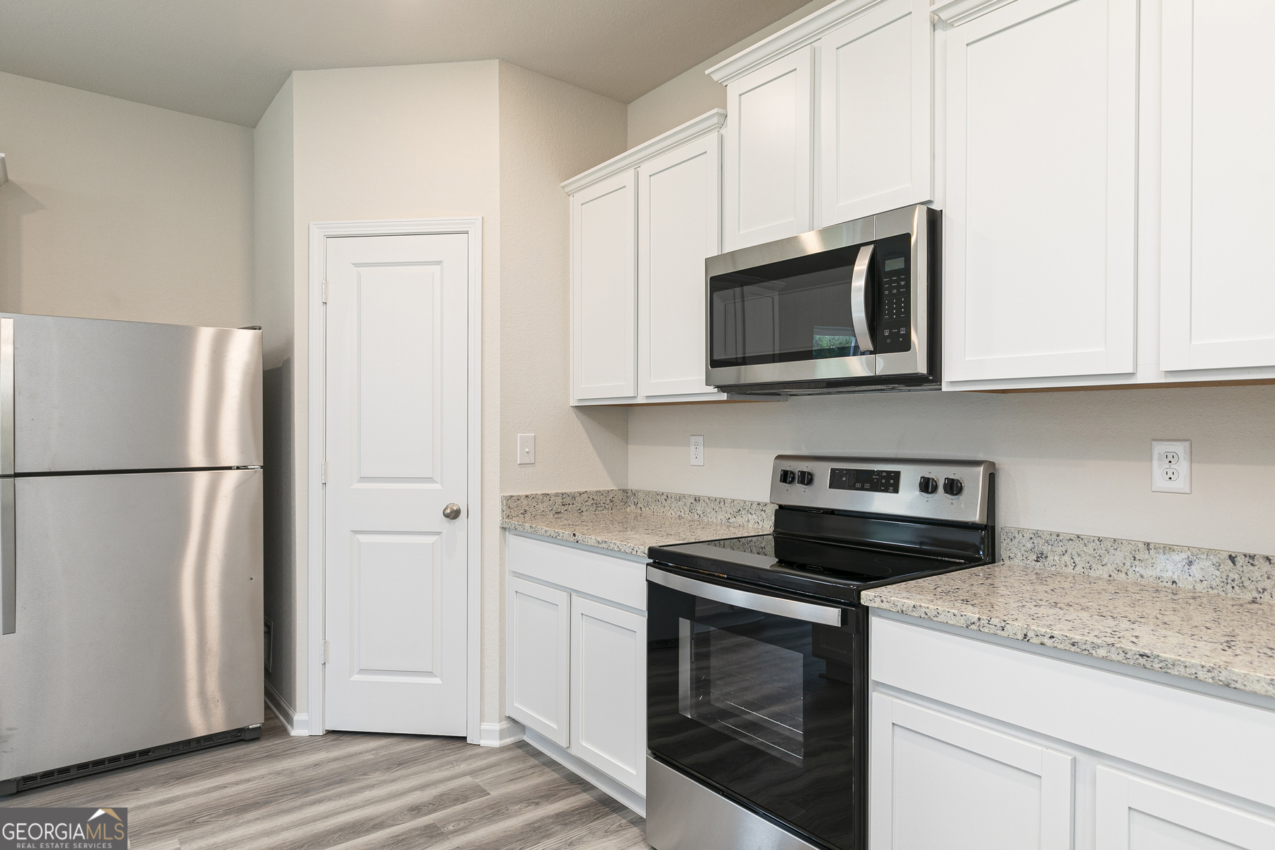 620 Slate Road Conyers, GA 30013 - Photo 11 of 22 a kitchen with stainless steel appliances granite countertop white cabinets stove a microwave and a refrigerator