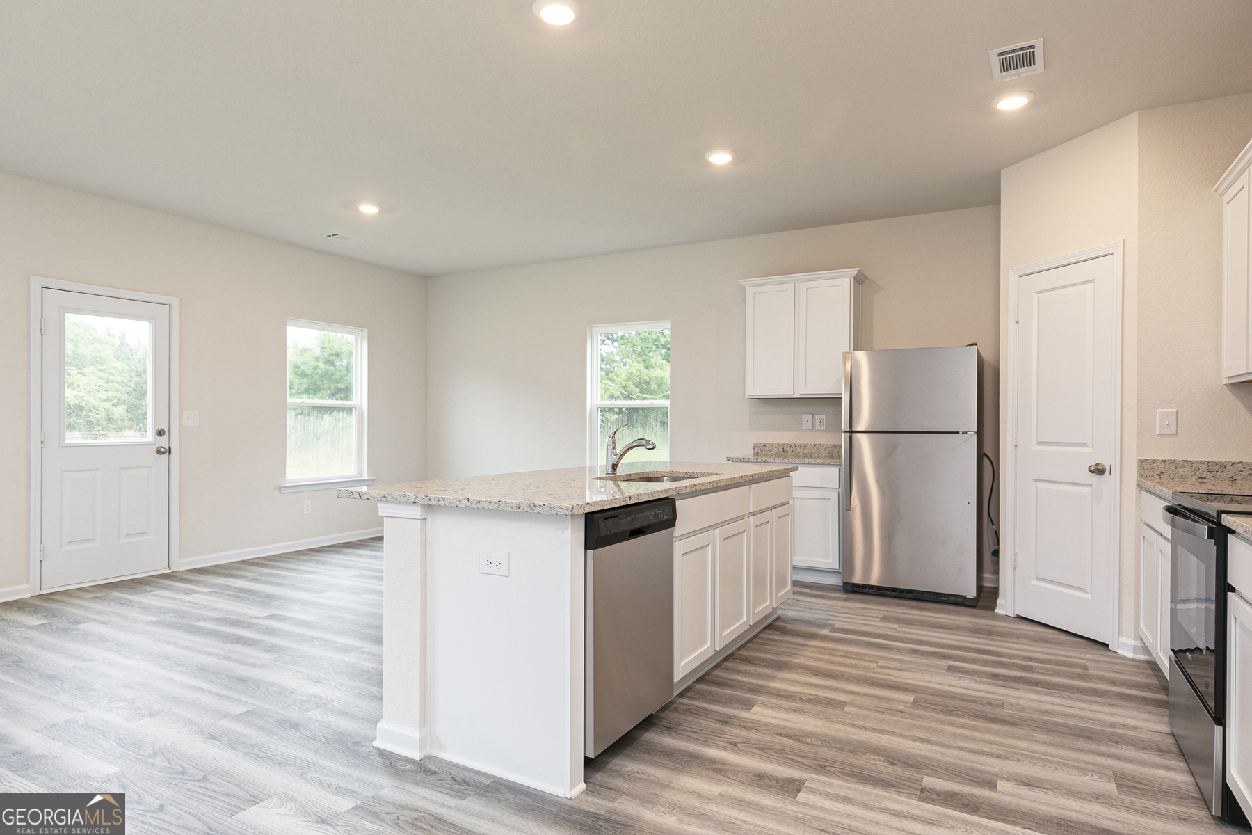 620 Slate Road Conyers, GA 30013 - Photo 10 of 22 a kitchen with granite countertop a refrigerator oven a sink dishwasher and white cabinets with wooden floor