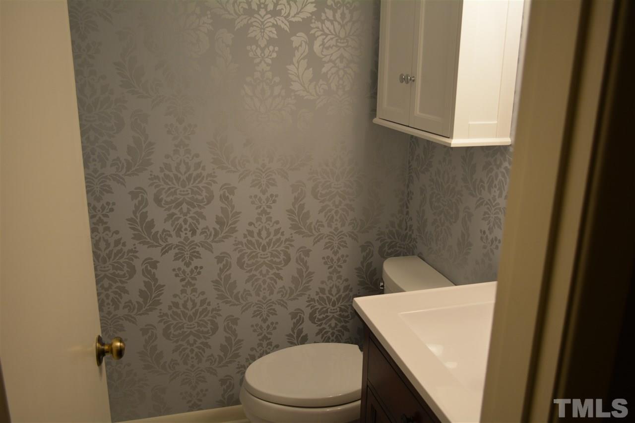 2604 Patrick Road Raleigh, NC 27604 - Photo 8 of 9 a white toilet sitting next to a white sink and vanity