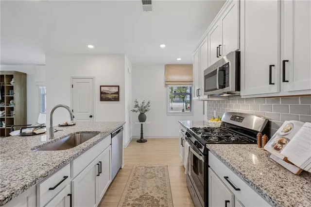 a spacious bathroom with a granite countertop sink a mirror and a shower