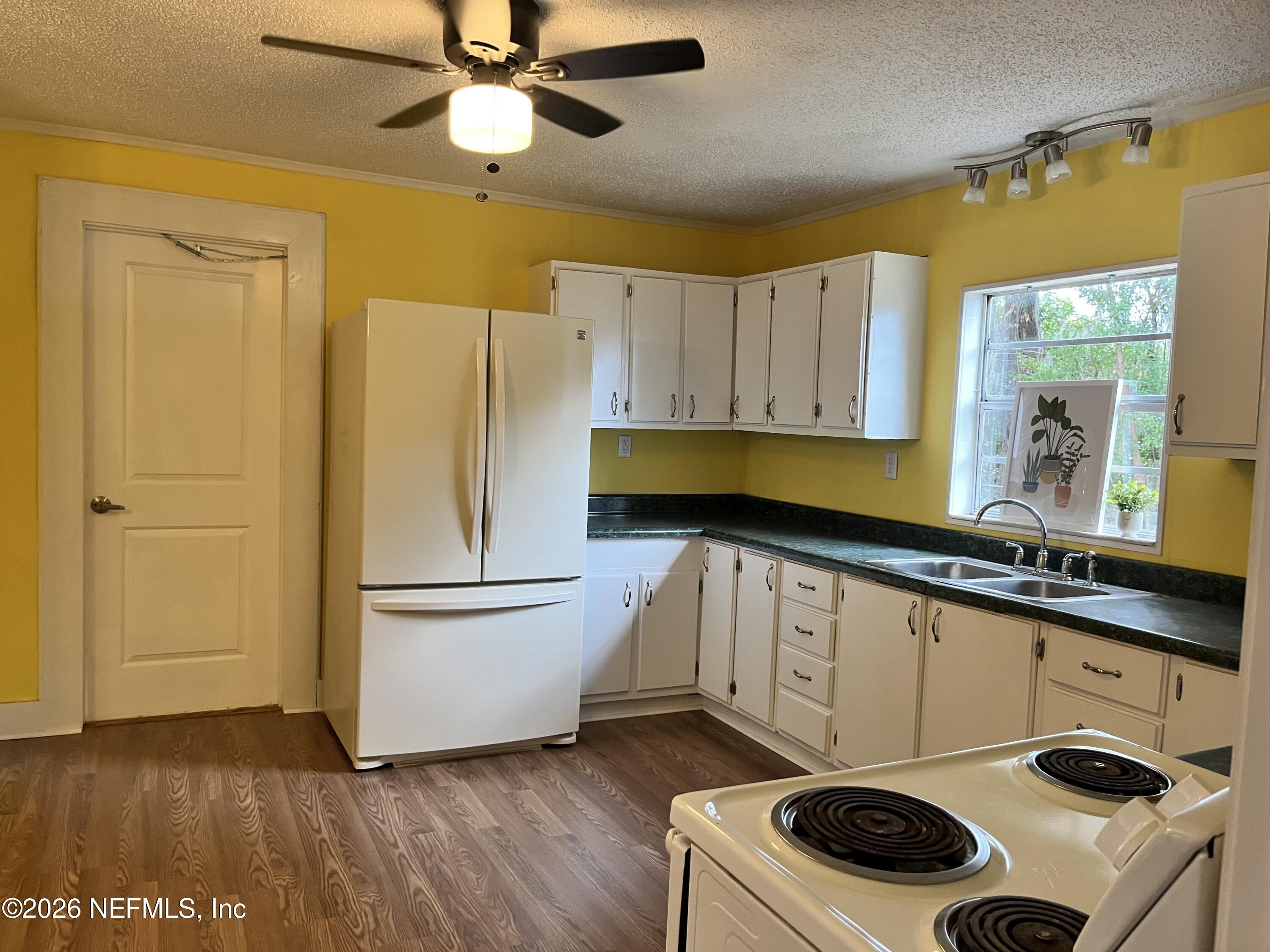 624 North Lake Street Starke, FL 32091 - Photo 17 of 34 a kitchen with a sink a refrigerator and cabinets