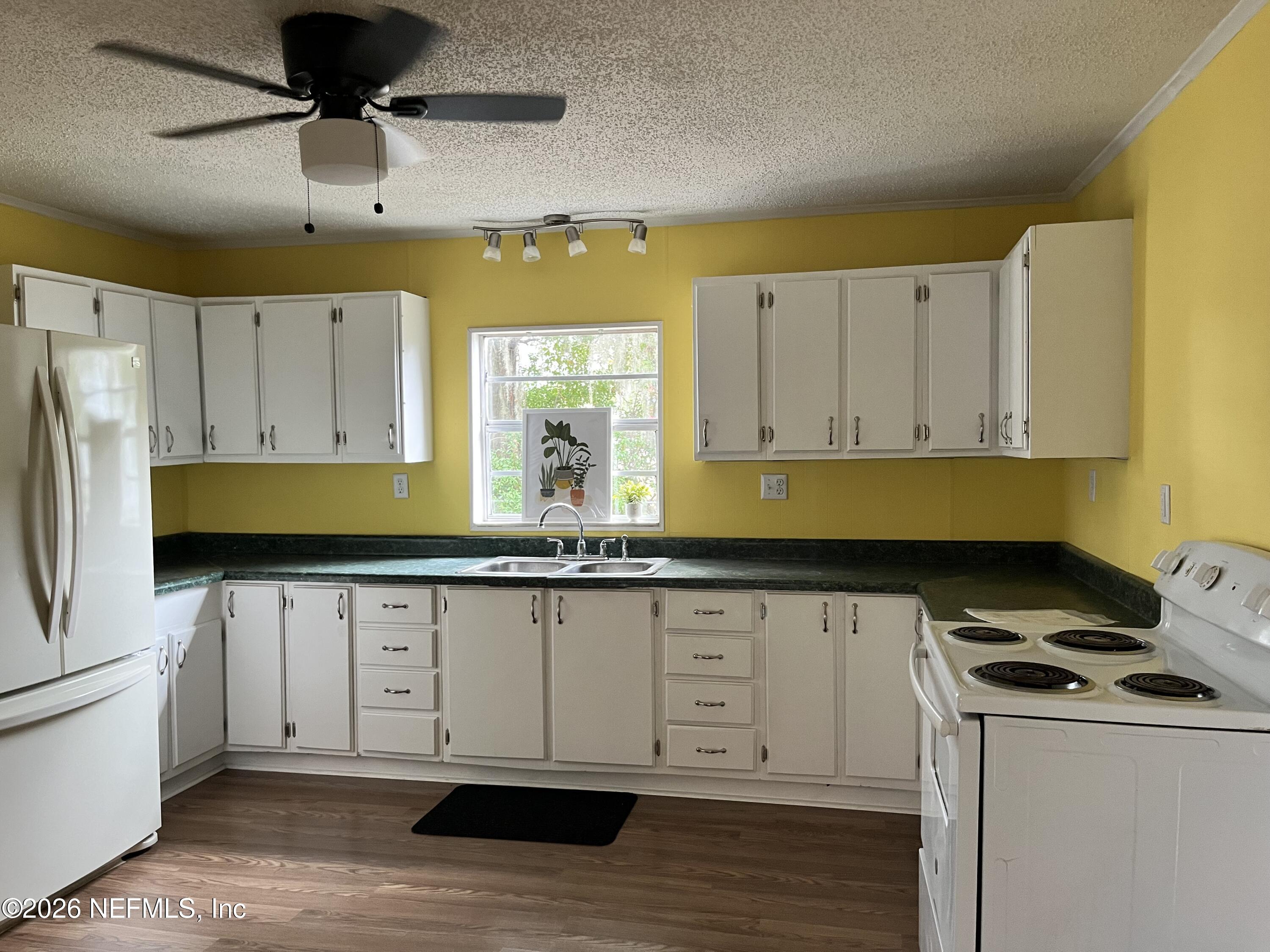 624 North Lake Street Starke, FL 32091 - Photo 26 of 34 a kitchen with granite countertop a sink a stove and refrigerator