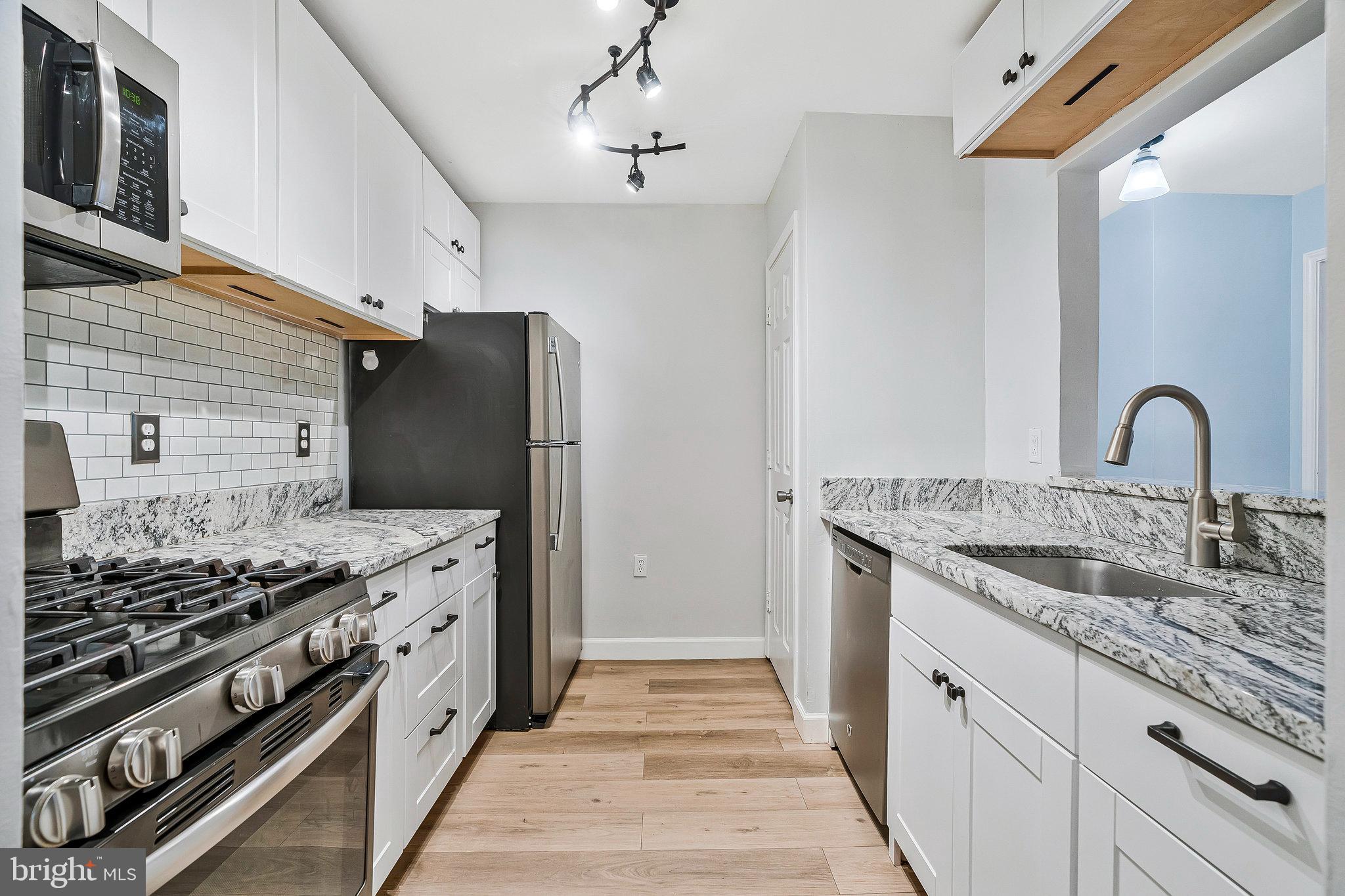 20991 Timber Ridge Terrace, Unit 103 Ashburn, VA 20147 - Photo 11 of 58 a kitchen with stainless steel appliances granite countertop a stove and a sink