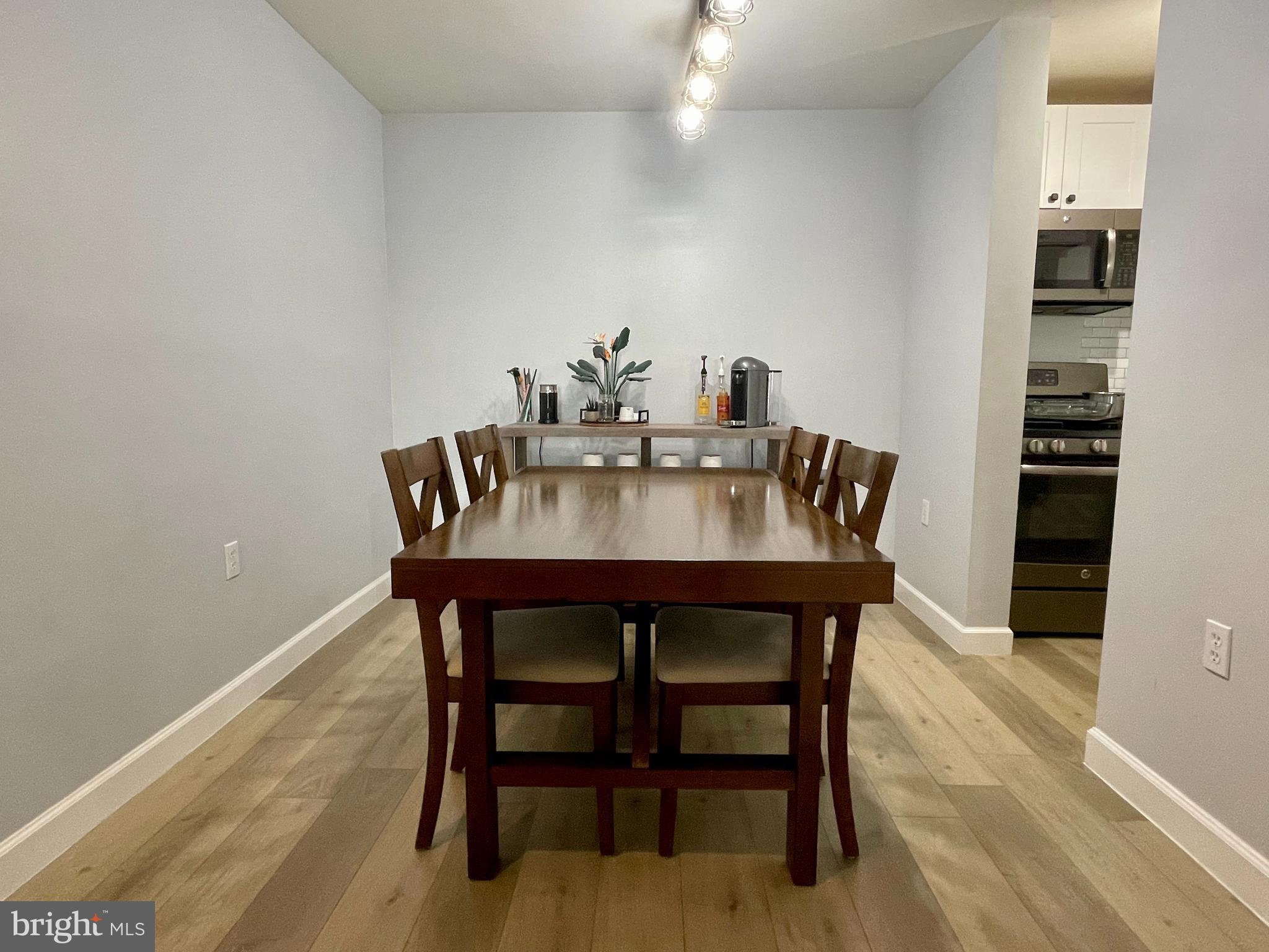20991 Timber Ridge Terrace, Unit 103 Ashburn, VA 20147 - Photo 13 of 58 a view of a dining room with furniture and wooden floor