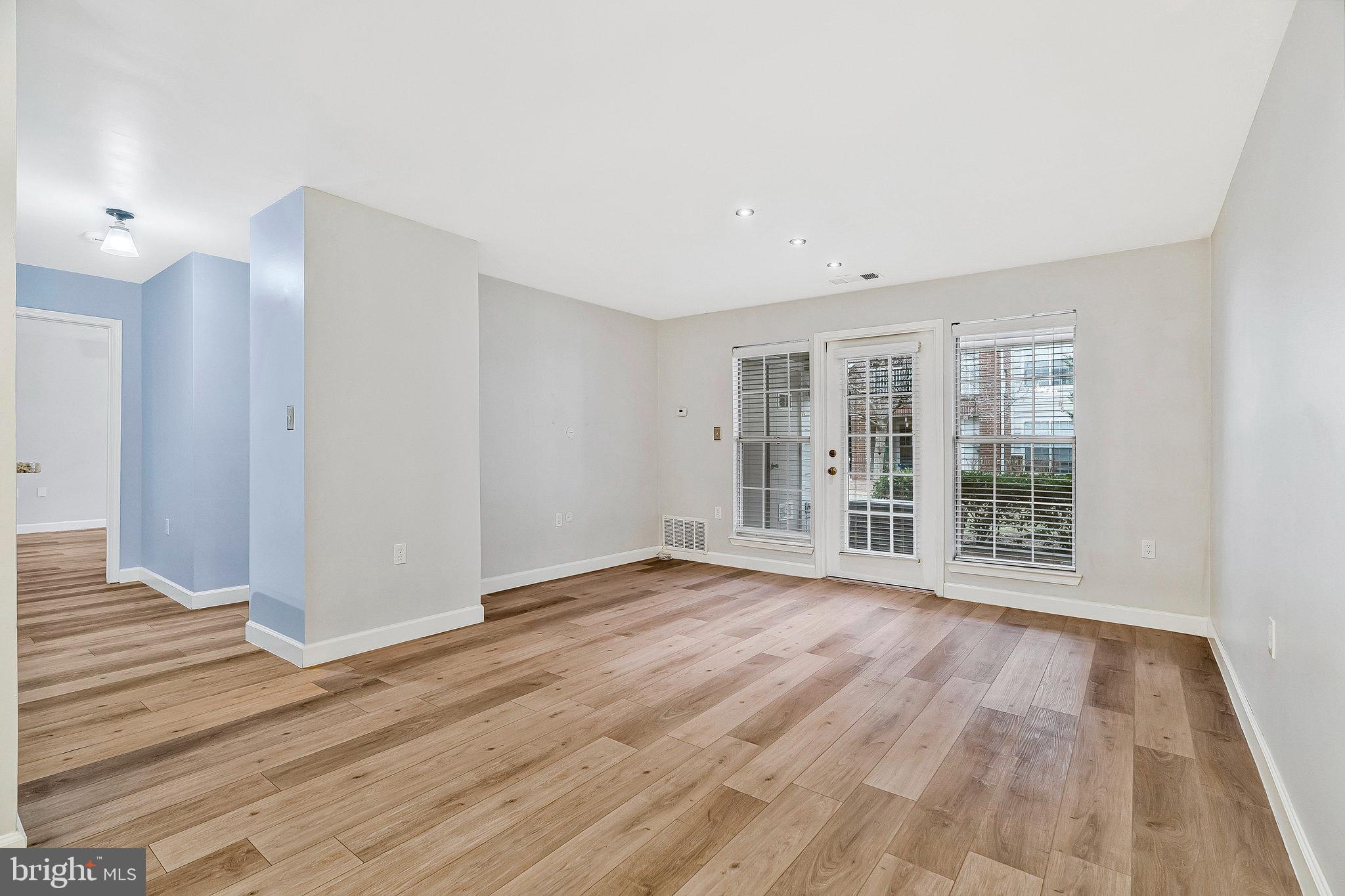 20991 Timber Ridge Terrace, Unit 103 Ashburn, VA 20147 - Photo 14 of 58 a view of an empty room with wooden floor and a window