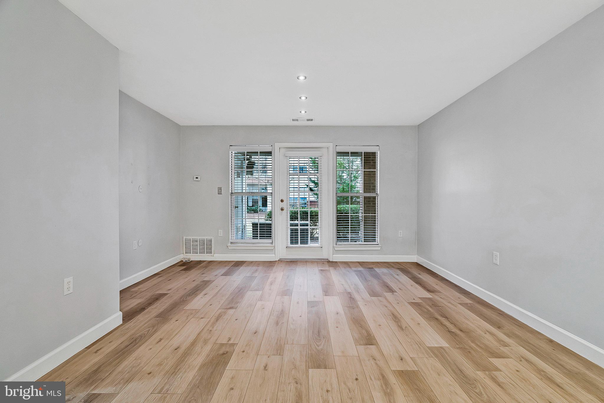 20991 Timber Ridge Terrace, Unit 103 Ashburn, VA 20147 - Photo 15 of 58 wooden floor in an empty room with a window