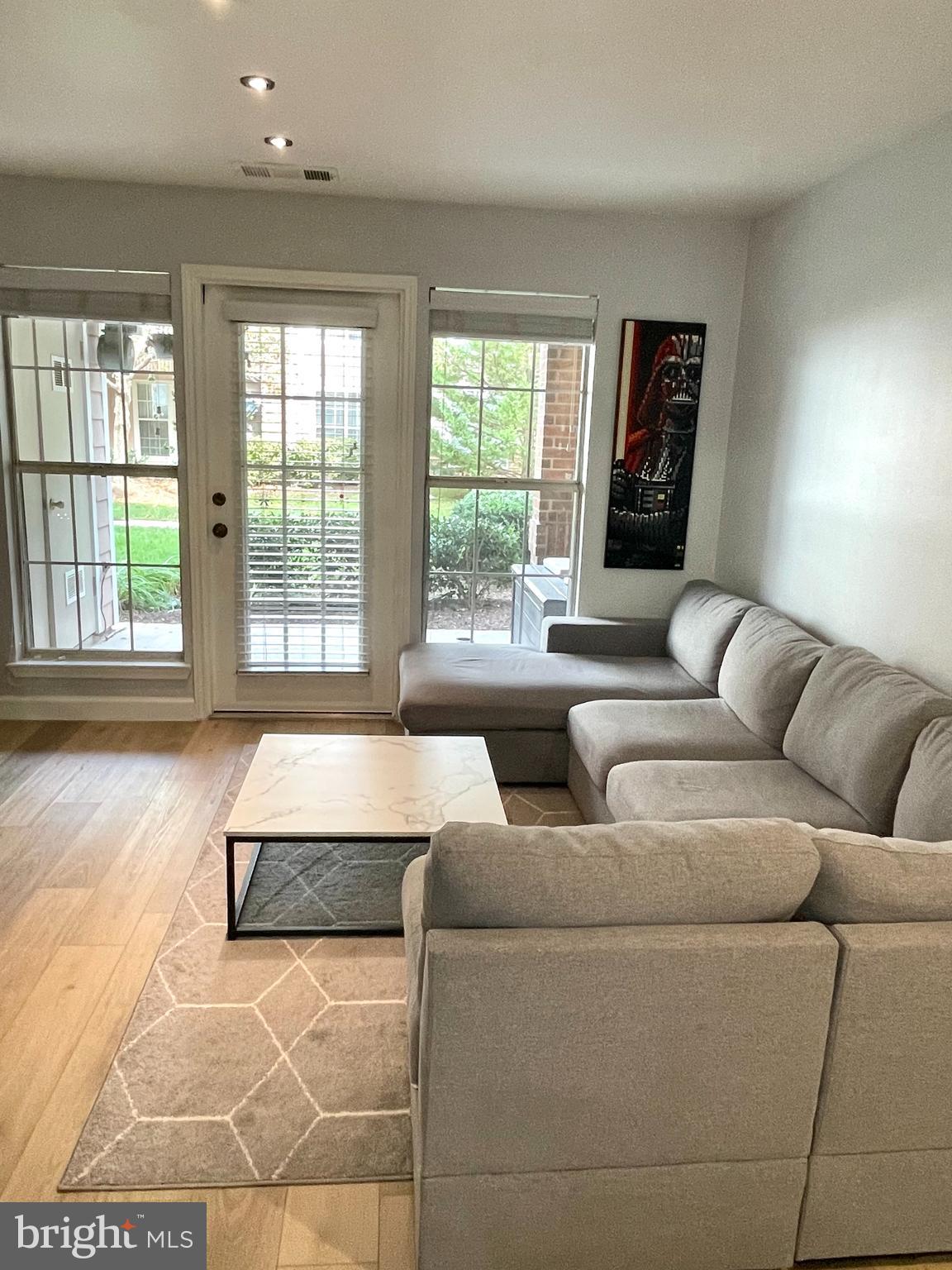 20991 Timber Ridge Terrace, Unit 103 Ashburn, VA 20147 - Photo 16 of 58 a living room with furniture and a large window