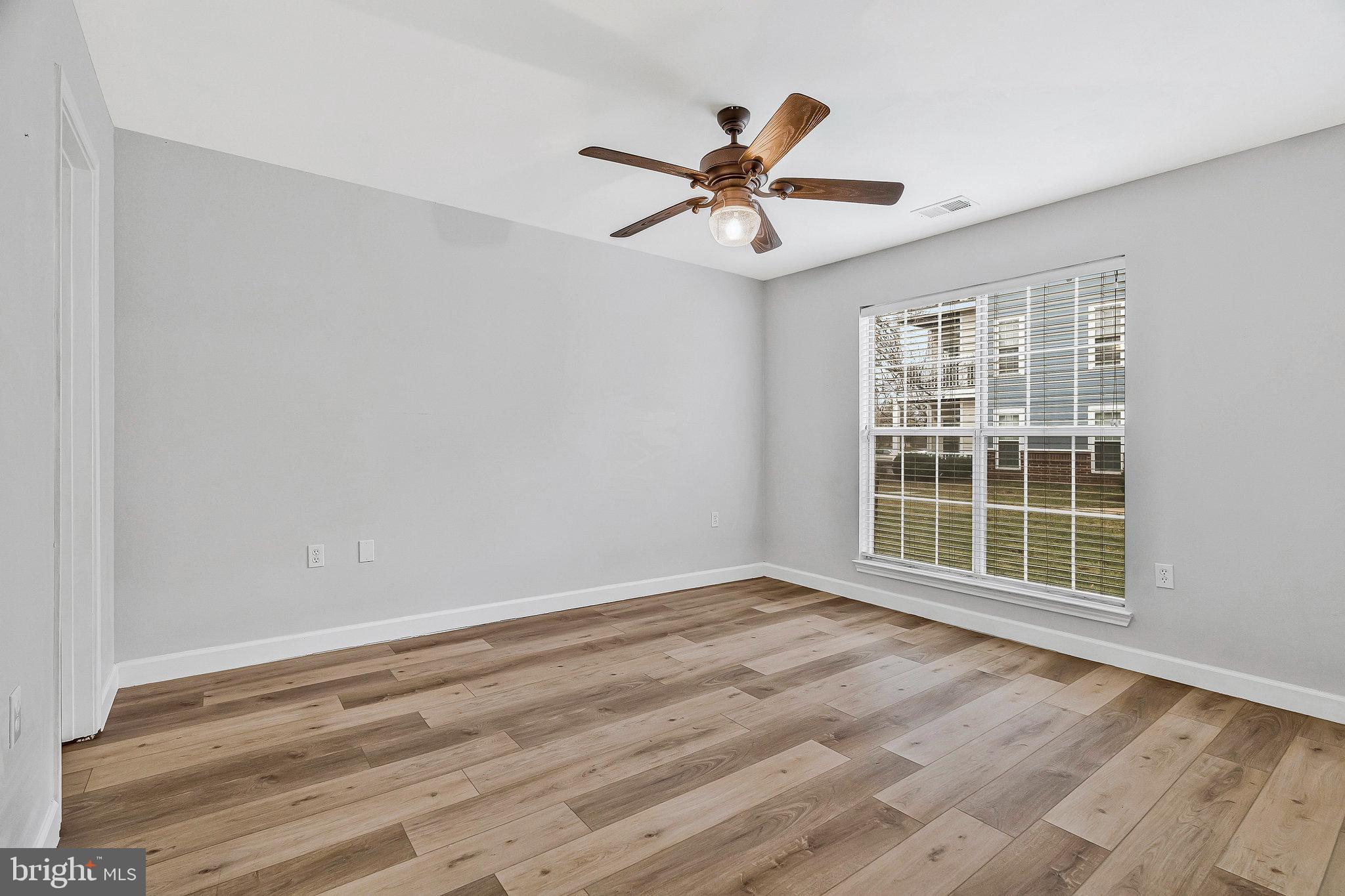 20991 Timber Ridge Terrace, Unit 103 Ashburn, VA 20147 - Photo 20 of 58 a view of a livingroom with a ceiling fan and wooden floor