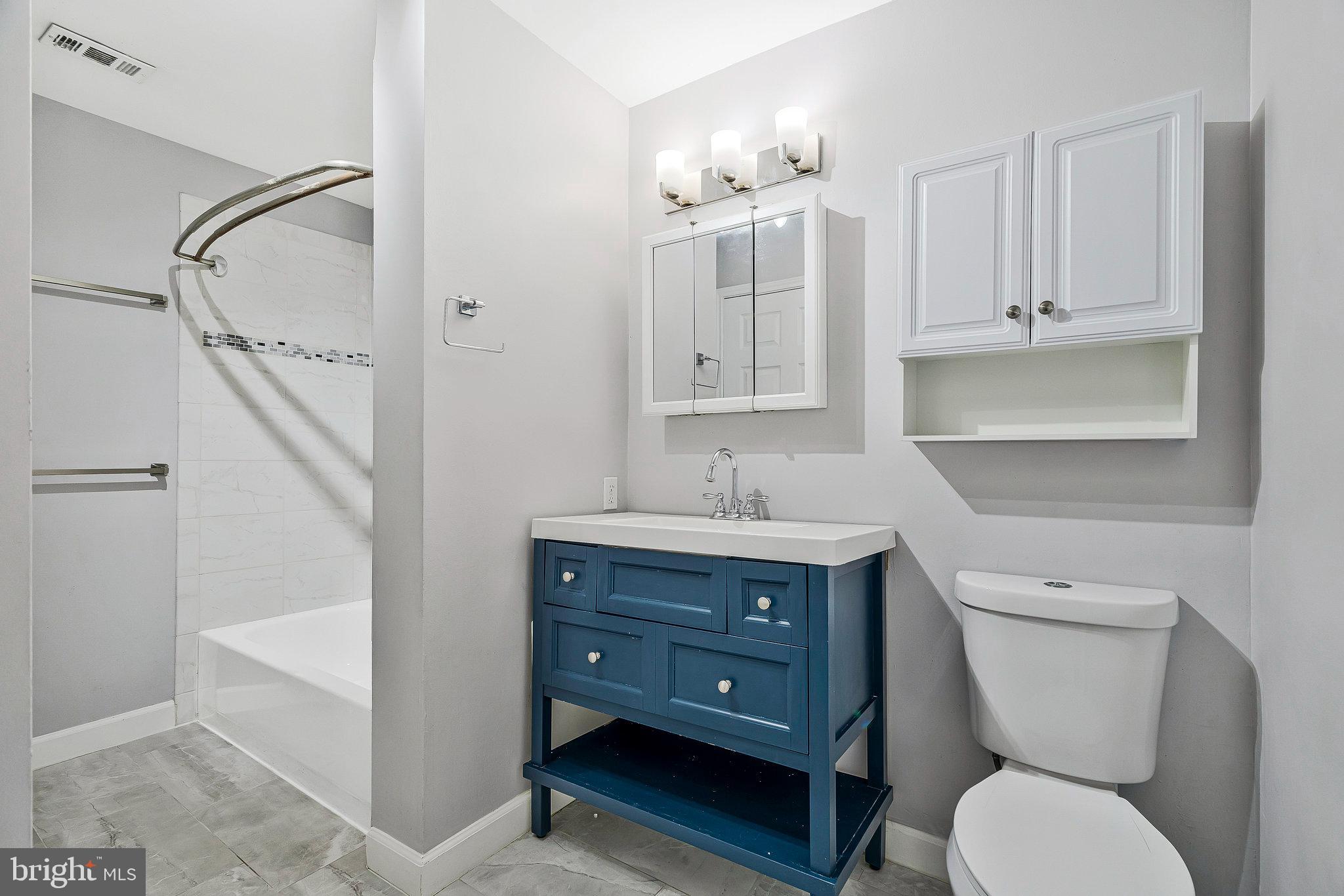 20991 Timber Ridge Terrace, Unit 103 Ashburn, VA 20147 - Photo 23 of 58 a bathroom with a toilet a sink and vanity