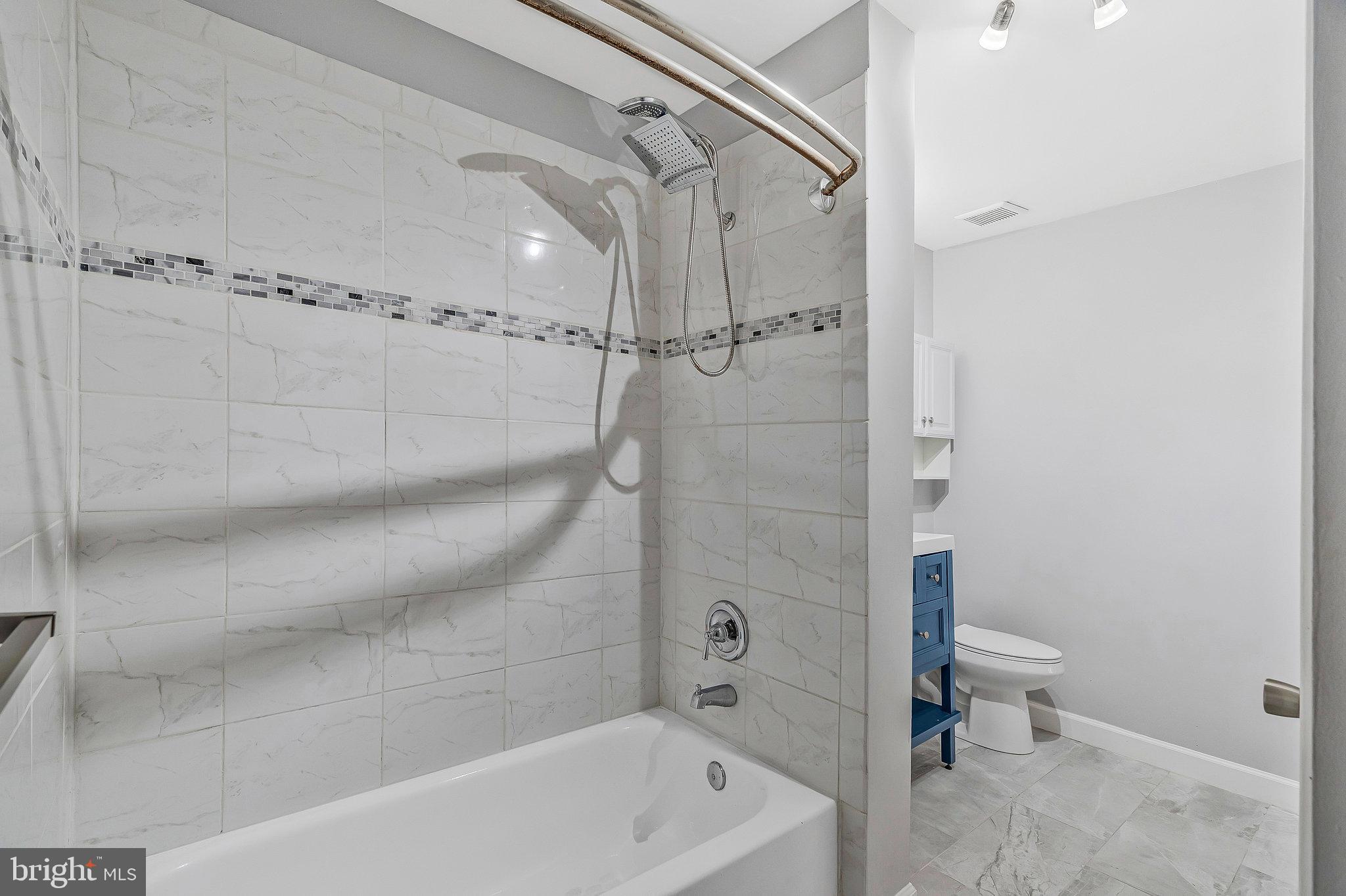 20991 Timber Ridge Terrace, Unit 103 Ashburn, VA 20147 - Photo 24 of 58 a bathroom with a shower and a toilet
