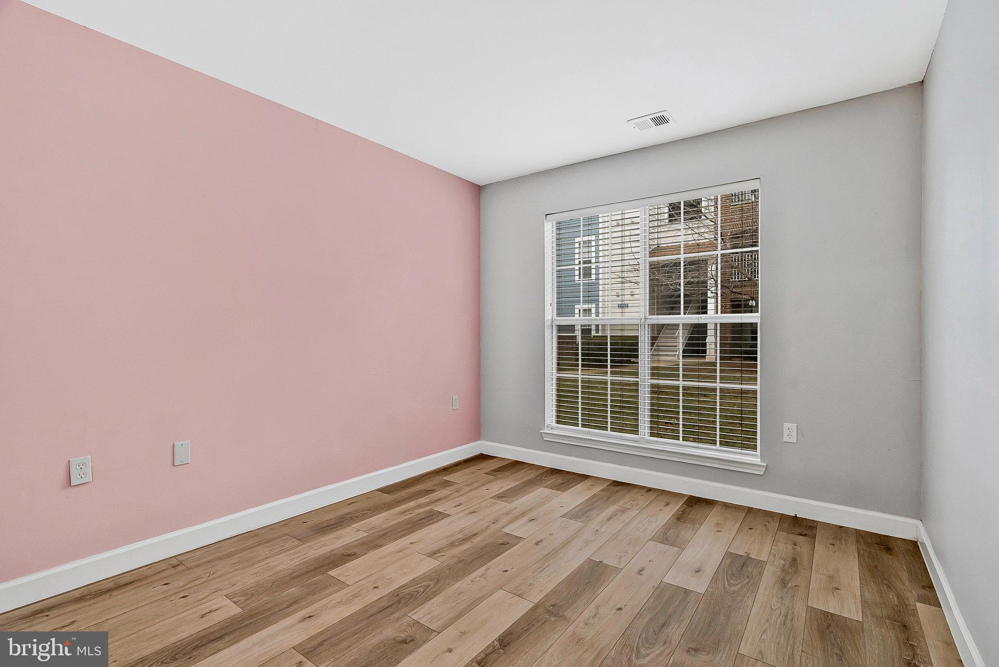 20991 Timber Ridge Terrace, Unit 103 Ashburn, VA 20147 - Photo 26 of 58 an empty room with wooden floor and windows