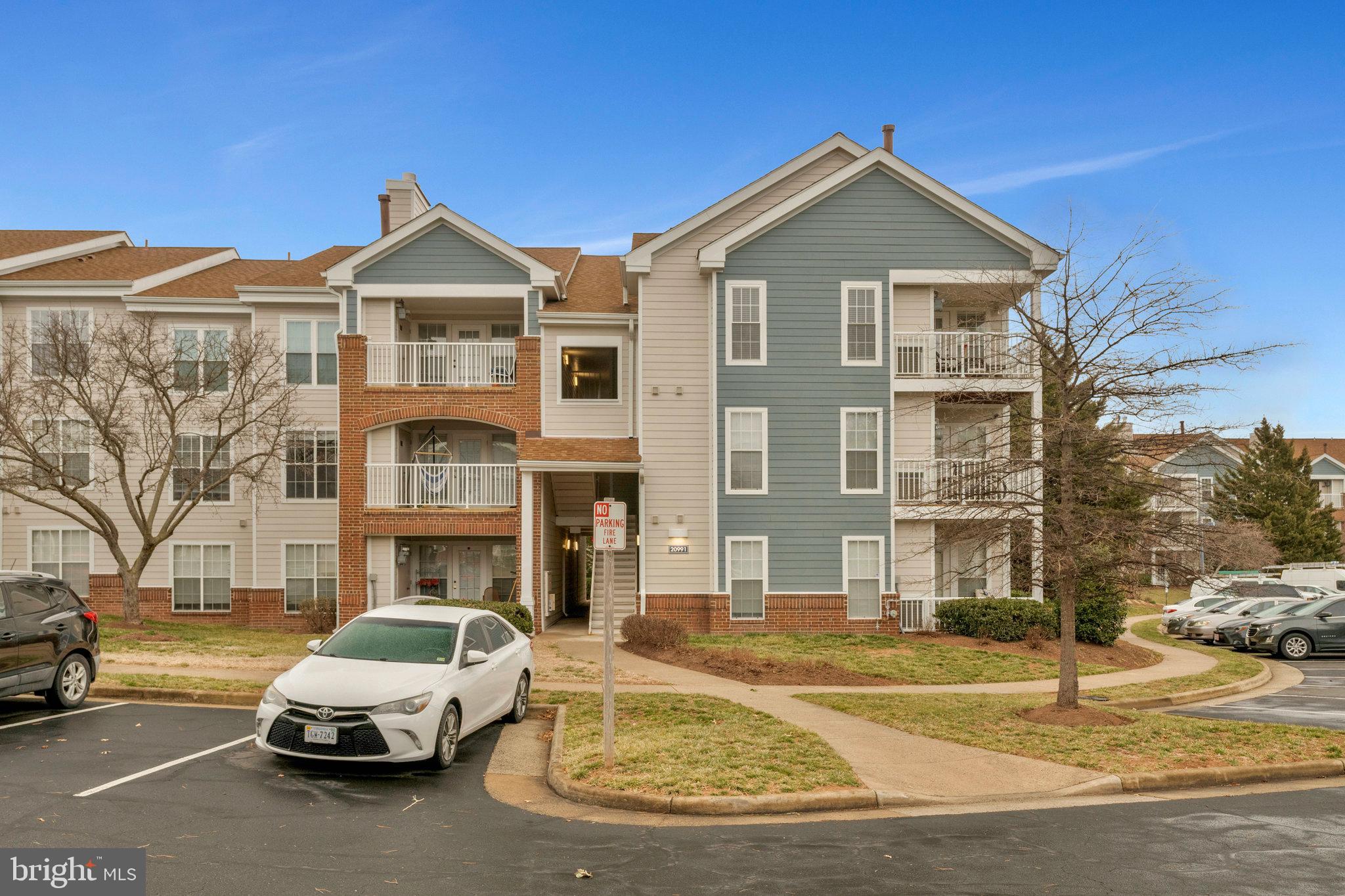 20991 Timber Ridge Terrace, Unit 103 Ashburn, VA 20147 - Photo 34 of 58 a front view of a house with a yard
