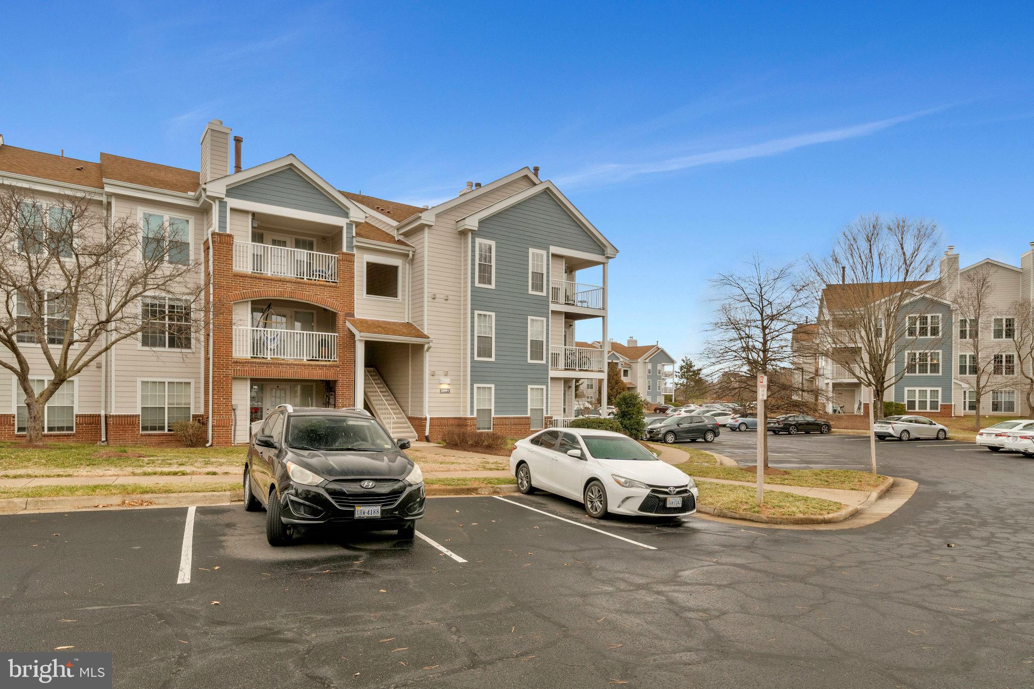 20991 Timber Ridge Terrace, Unit 103 Ashburn, VA 20147 - Photo 35 of 58 a view of a building with cars parked in front of it