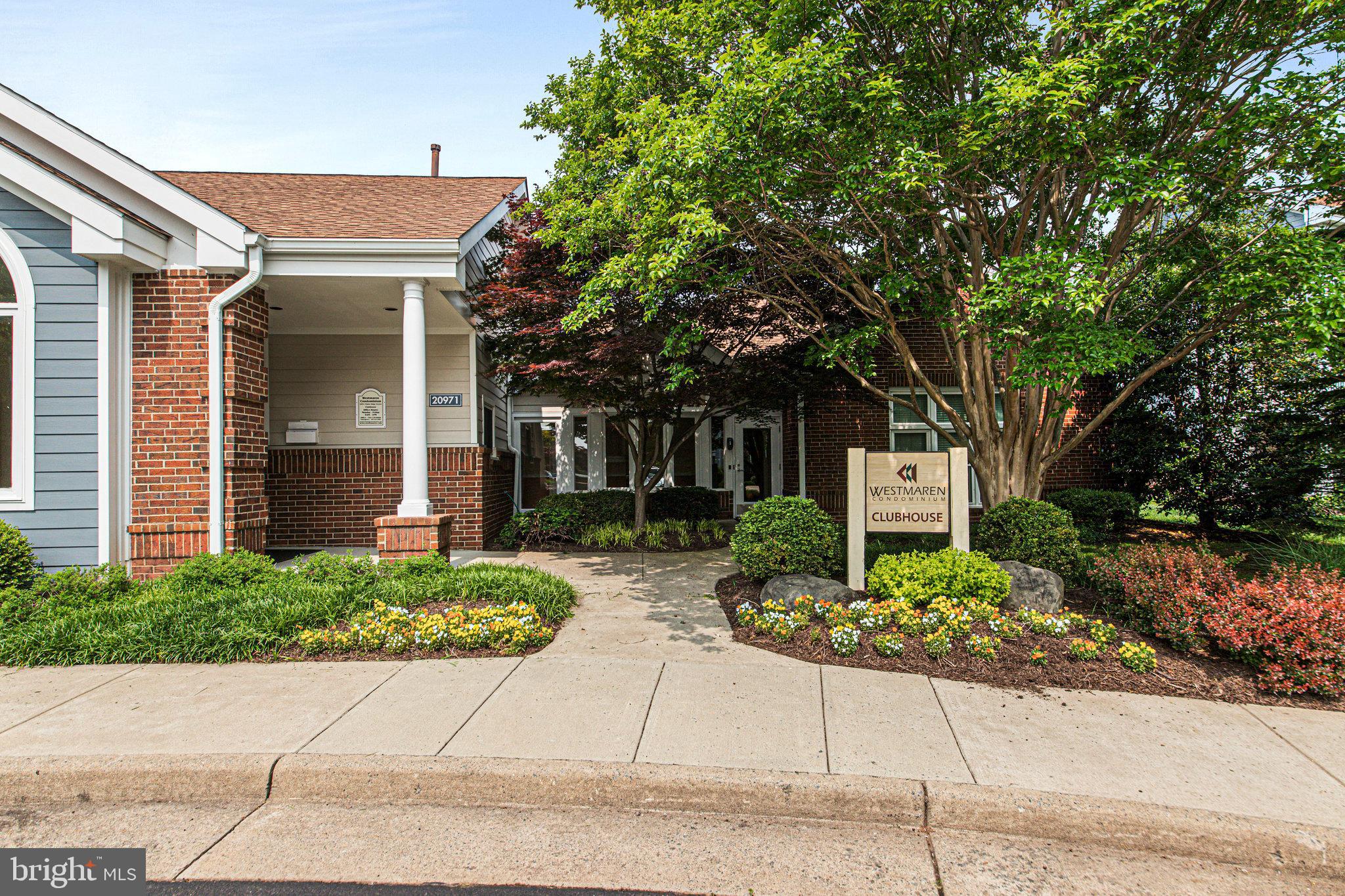 20991 Timber Ridge Terrace, Unit 103 Ashburn, VA 20147 - Photo 38 of 58 a front view of a house with a garden and plants