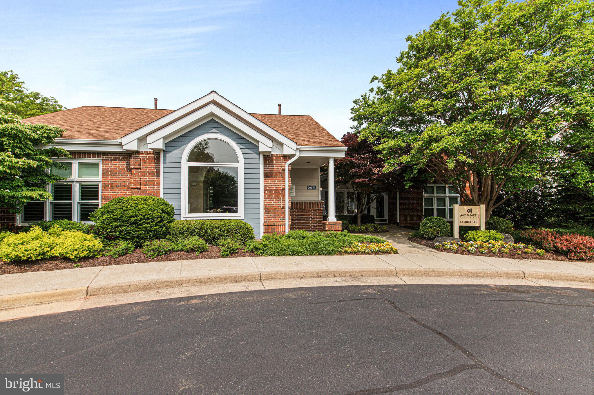 20991 Timber Ridge Terrace, Unit 103 Ashburn, VA 20147 - Photo 40 of 58 front view of a house next to a yard