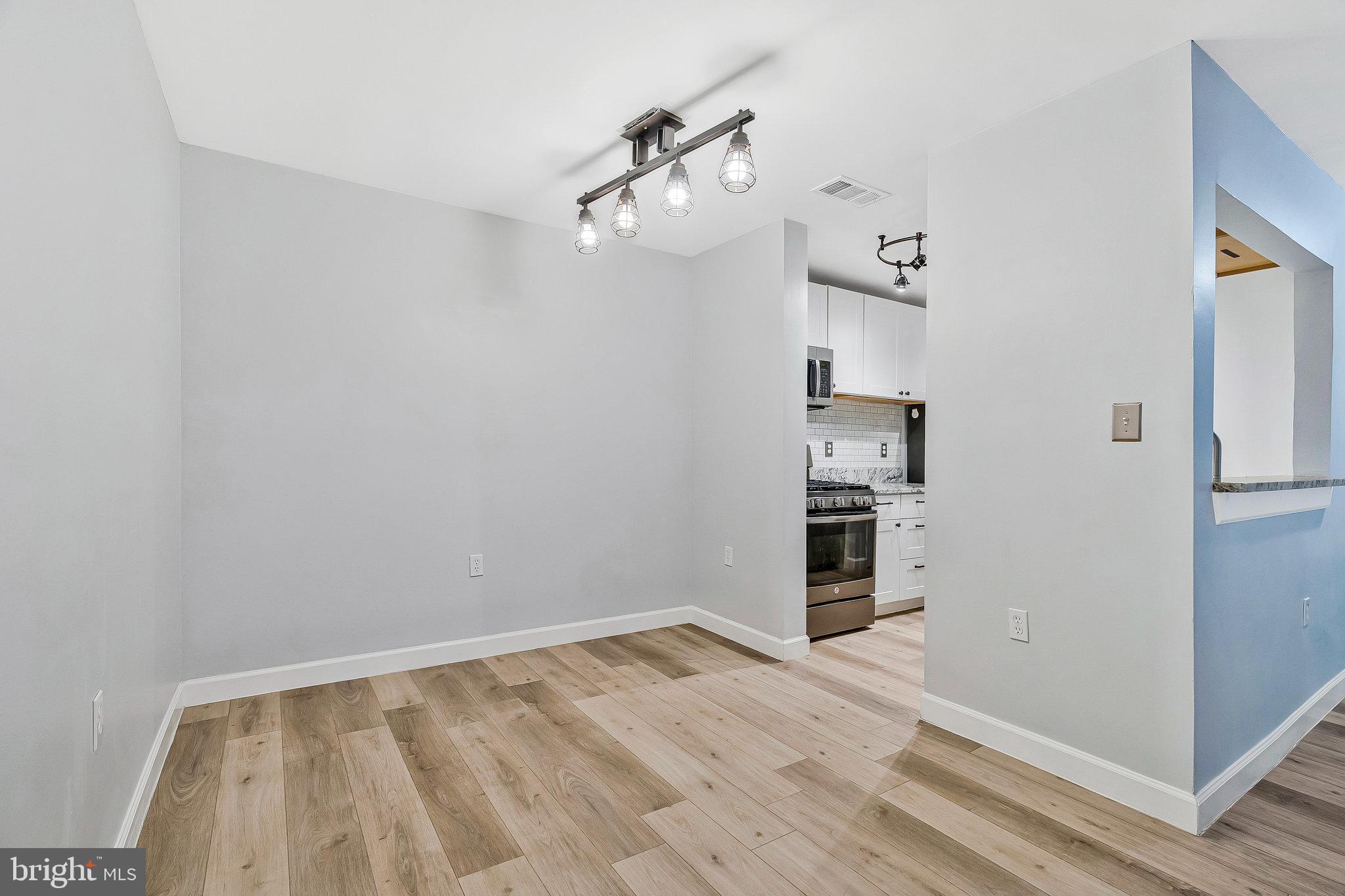 20991 Timber Ridge Terrace, Unit 103 Ashburn, VA 20147 - Photo 6 of 58 a view of a room with wooden floor and ceiling fan