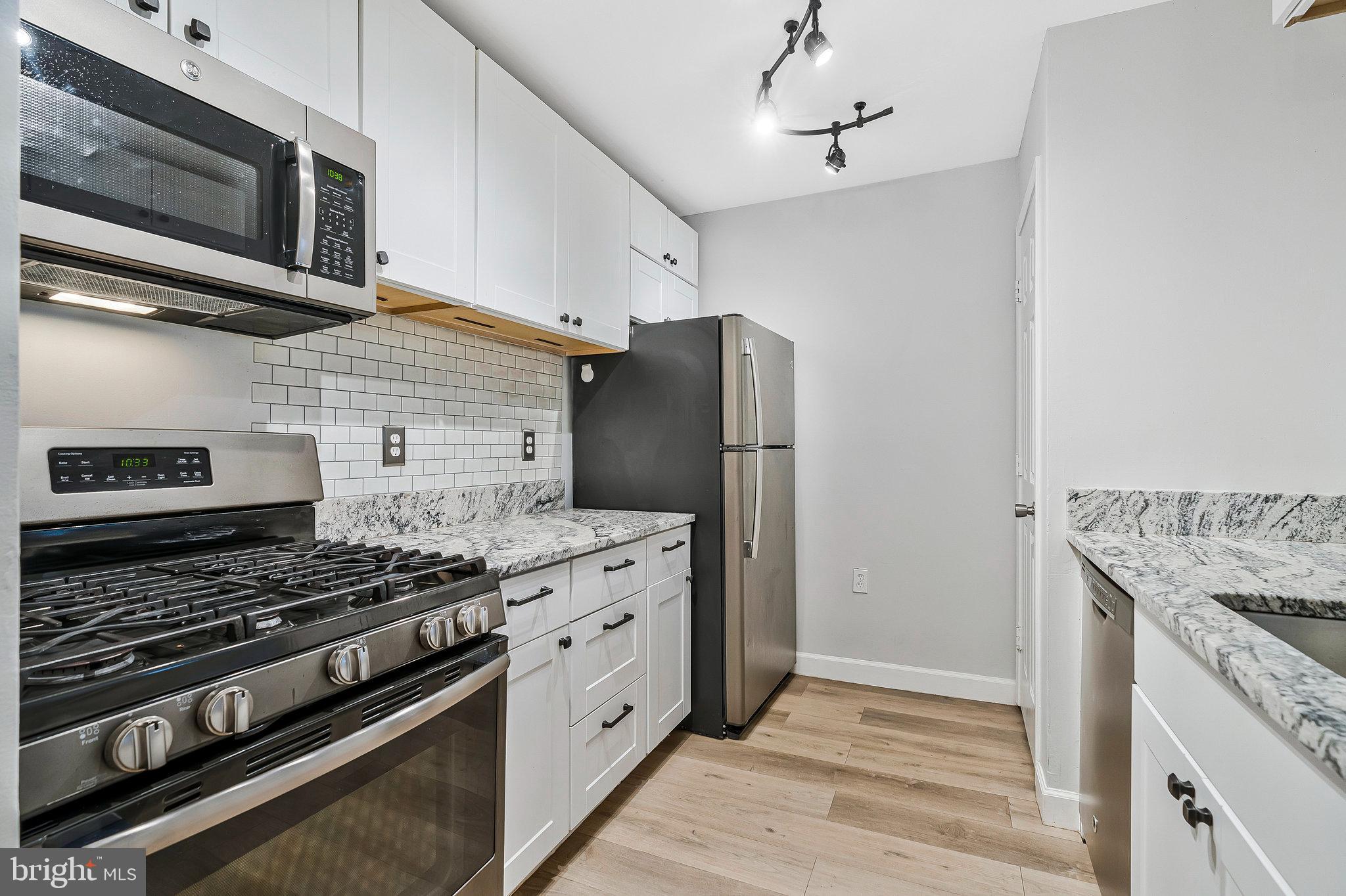 20991 Timber Ridge Terrace, Unit 103 Ashburn, VA 20147 - Photo 7 of 58 a kitchen with stainless steel appliances granite countertop a stove and a refrigerator