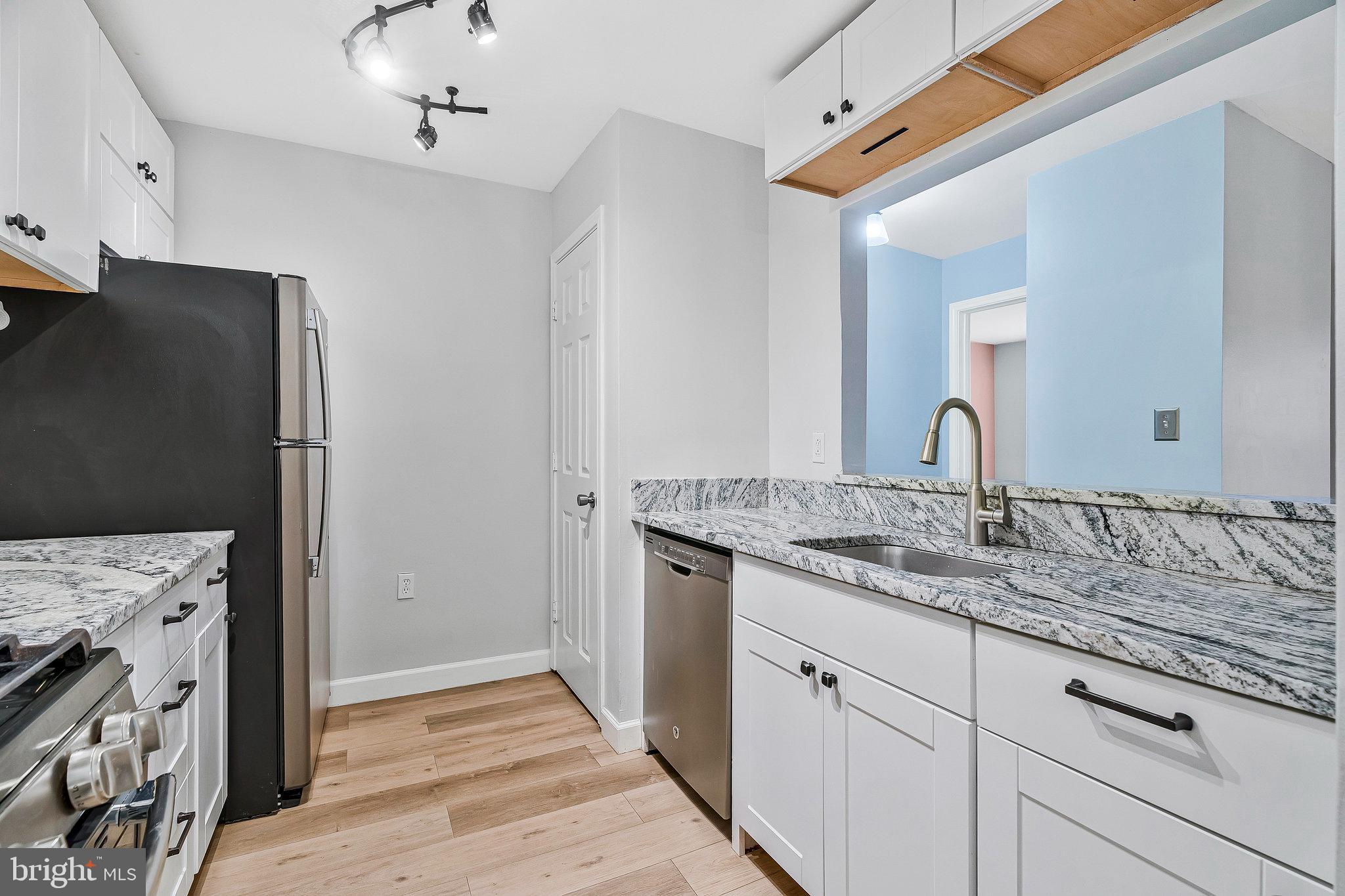 20991 Timber Ridge Terrace, Unit 103 Ashburn, VA 20147 - Photo 8 of 58 a kitchen with stainless steel appliances granite countertop a sink and a refrigerator