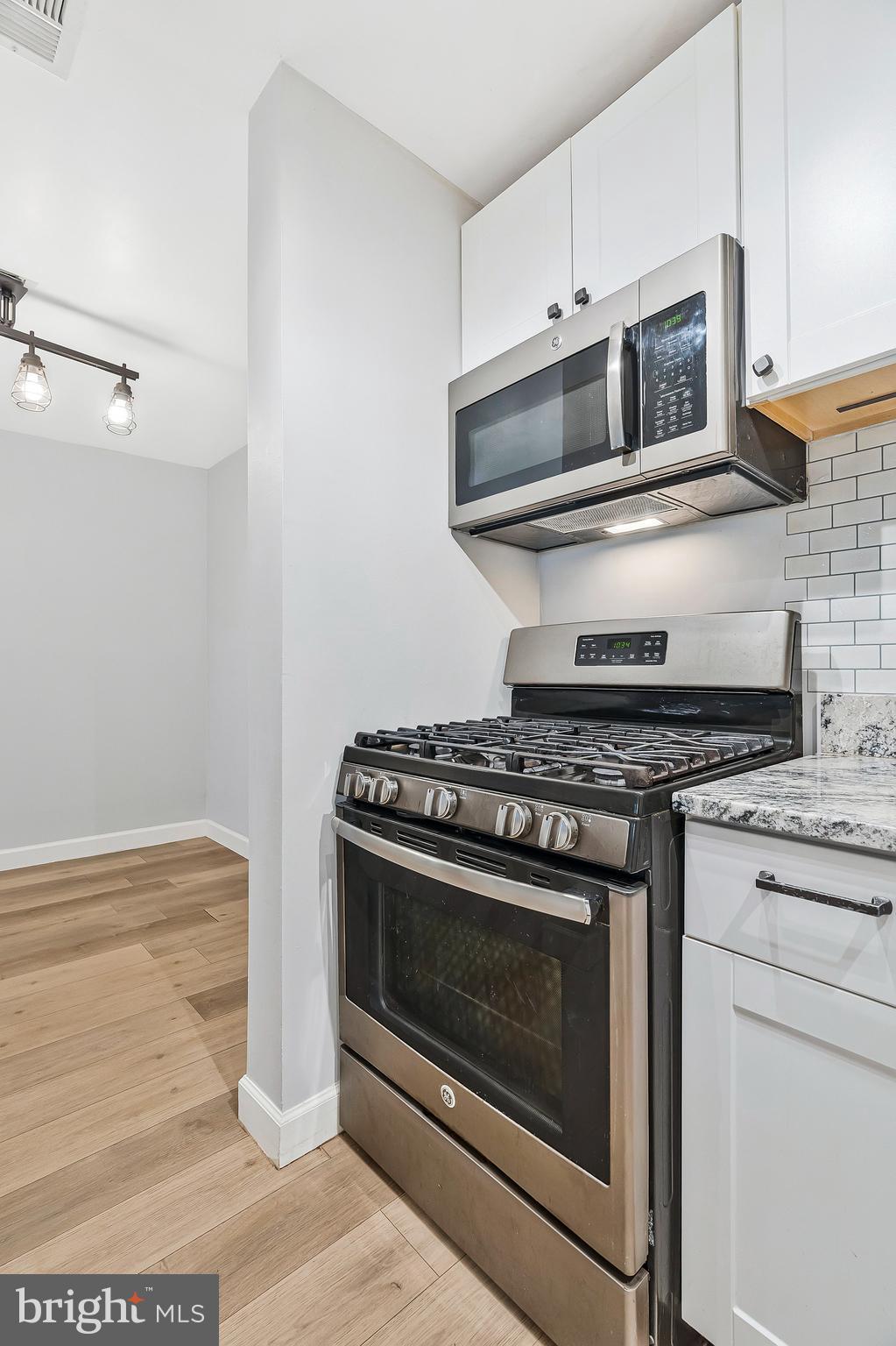 20991 Timber Ridge Terrace, Unit 103 Ashburn, VA 20147 - Photo 9 of 58 a stove top oven sitting inside of a kitchen