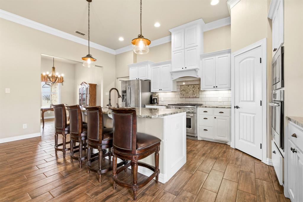 146 Mesquite Ridge Lane Lawn, TX 79530 - Photo 14 of 40 a kitchen with stainless steel appliances a dining table chairs stove and white cabinets